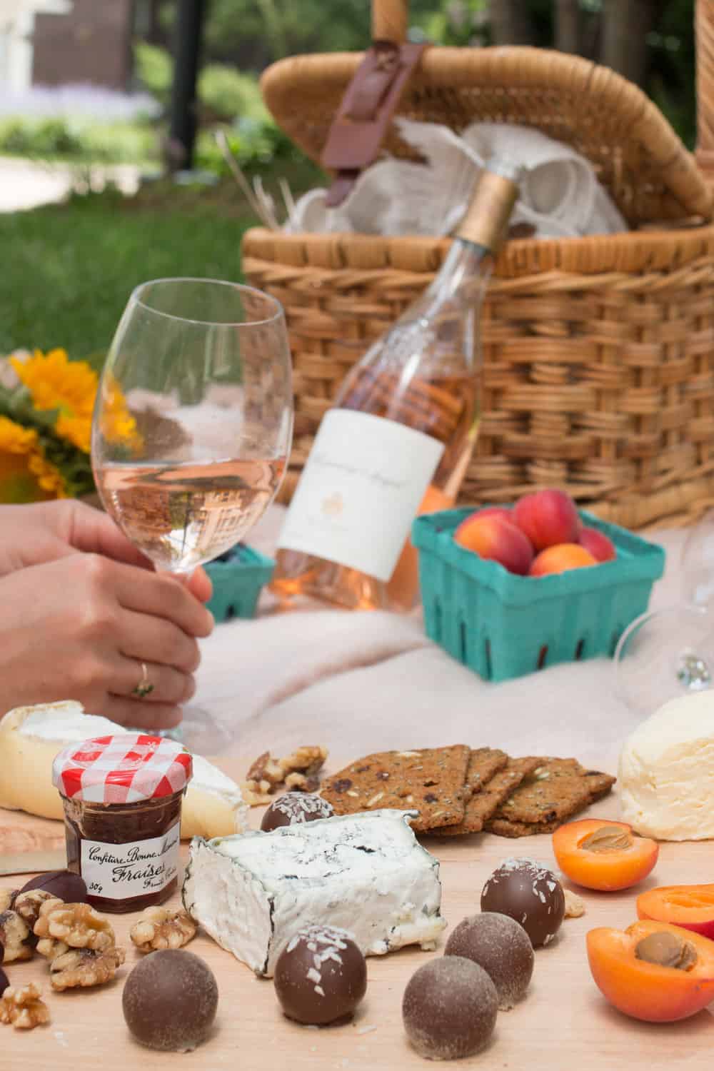 wine, picnic basket, and food for how to host a parisian picnic 