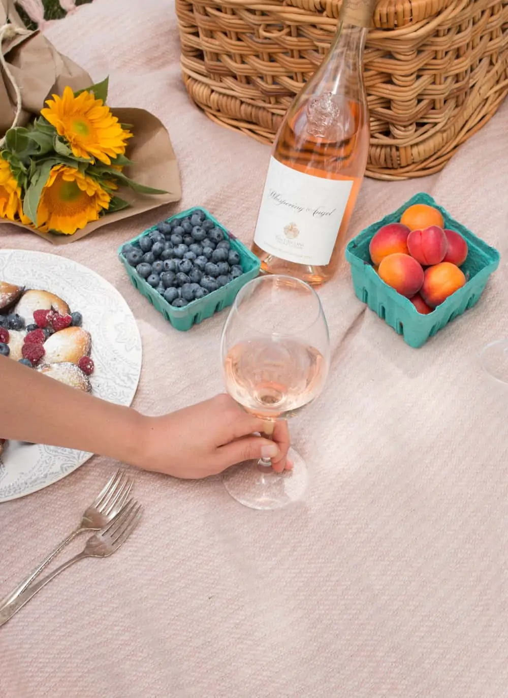 picnic setup with sunflower, fruits and wine for how to host a parisian picnic