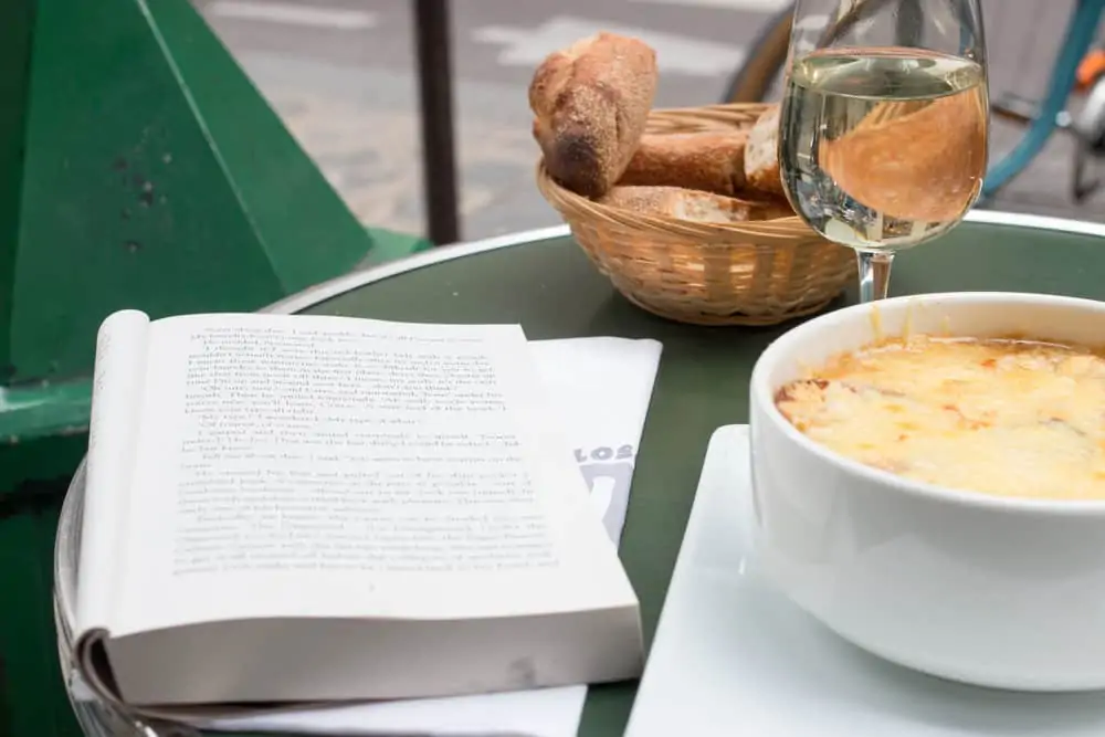 french onion soup and a book in paris, france cafe