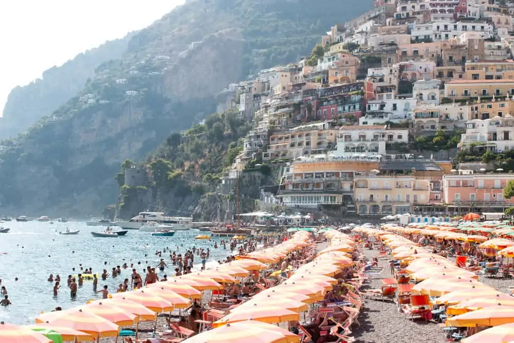 shore at the beach with beach umbrellas and sharing what I am Packing for Italy