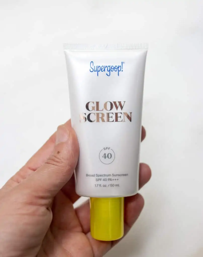 hand holding Supergoop Sunscreen glow screen