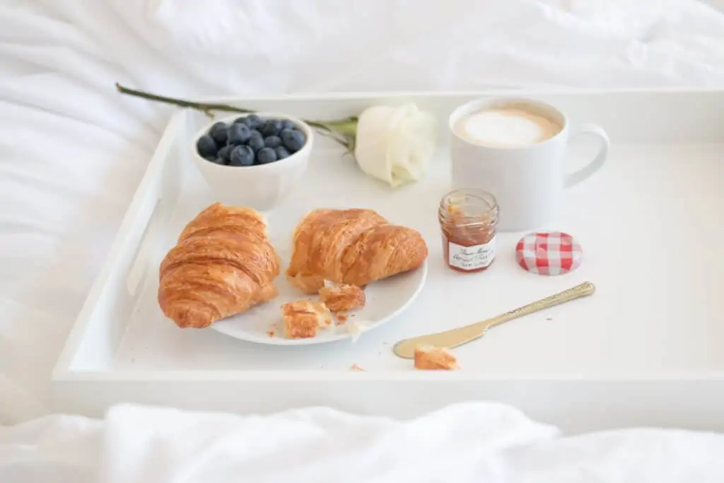 croissant , coffee, blueberries, and jam for breakfast 