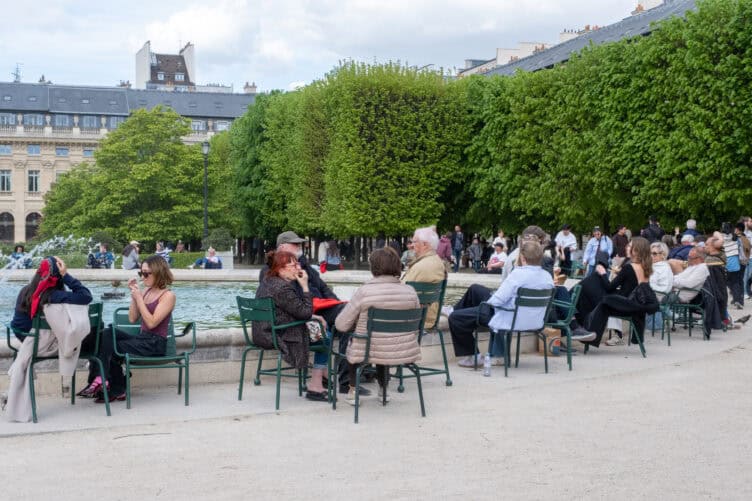 Parisians enjoying a picnic in Palais Royal around the fountain 
