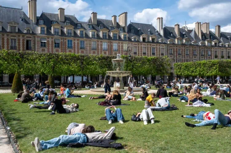 Parisians in Place des Vosges for picnic season spring sunny weather