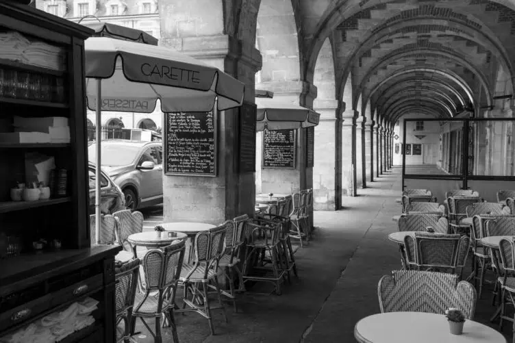 Place des Vosges Carette covered arch during a rainy day in Paris