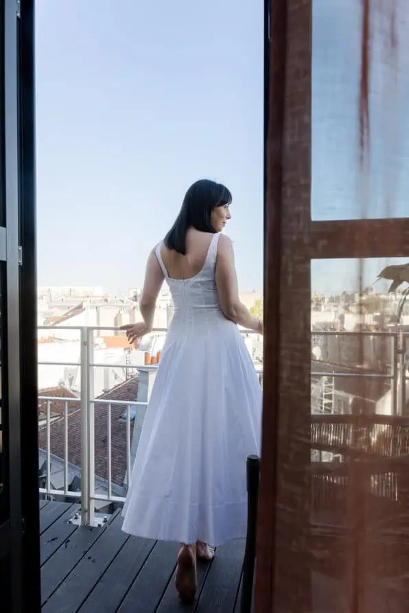rebecca plotnick looking out of Parisian hotel balcony at Hotel dame des Arts Paris 5th arrondissement