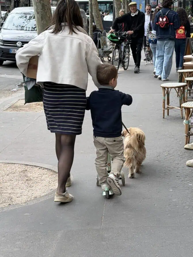 Parisian woman wearing tights walking kid to school